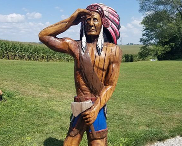 chainsaw carving of native american in traditional headdress