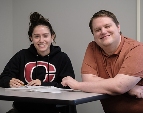 Student and instructor at table with textbook