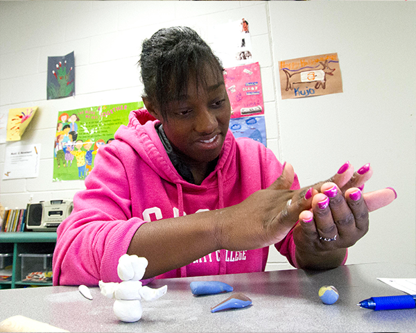 Student working with clay in daycare setting