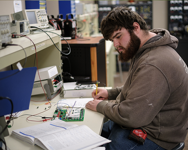 Student working with wires and breadboard in lab