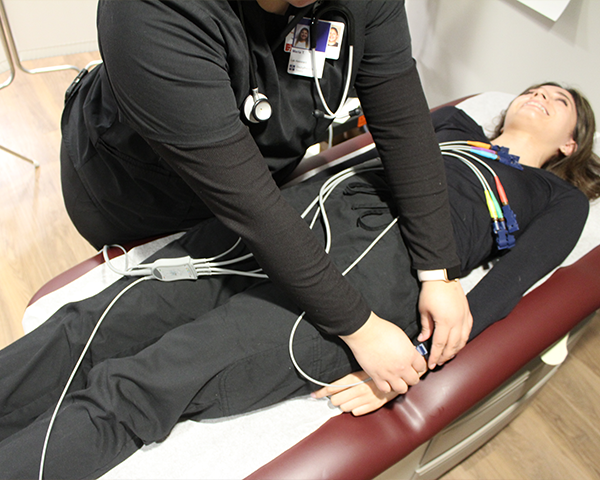 Medical assisting students practicing working with patient on table